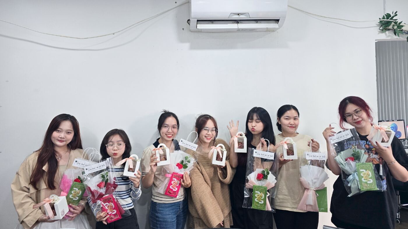 Nhân viên nữ MONA cầm quà tặng dịp lễ tri ân tại văn phòng